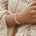 Dettaglio di un bracciale di perle d'acqua dolce barocche al polso con accenti in oro retrò - Stile Bohemien Perla d'Acqua Dolce (KB0137)