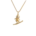 Macro view of gold-plated skateboarder pendant featuring sparkling zircon stone eyes - Surfer