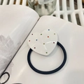 Dettaglio dell'elastico per capelli a cuore bianco con strass colorati su un libro - Bianco-Cuore Diamante Colorato-Elastico
