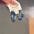 Detailansicht der silbernen S925 Creolen mit blauen Zirkonia auf einer Schmuckkarte - Silber Blaue Zirkonia Ring Stil