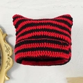 Détail du bonnet en tricot rayé rouge et noir avec oreilles de chat et texture épaisse - Rayures Rouges et Noires