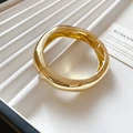 Close-up of gold chunky organic wave bangle showing the metal hinge and glossy finish - Gold - Irregular Twisted