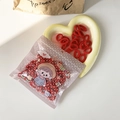 Pack of red elastic hair ties for girls in cartoon floral packaging on white surface - Red