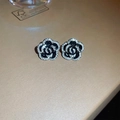 Detailed close-up of double-layered camellia stud earrings with black enamel and crystals - Silver-tone Black Stud Earrings (Silver Earring Post)