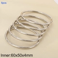 Set of 5 polished 4mm stainless steel silver bangles shown on beige leather - 5 Rings (KB205314-LO)