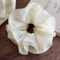 Dettaglio macro dell'elastico scrunchie crema a 4 strati con delicata trama a quadri - Beige / Beige