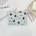 Close-up of quilted floral makeup bag with Lucky Kitten print and a pink rope zipper - Black Cat Dots
