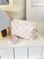 Close-up of quilted cotton cosmetic bag featuring pink bow patterns and a zipper puller - Pink Line-drawn Bow