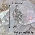 Silver leaf-shaped brooch with white rhinestones and a faux pearl detail, 60mm long - Silver Leaf