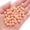 Frosted peach red acrylic round beads being held in hand for handmade DIY jewelry crafts - Peach Red