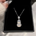 Gros plan d'un collier pendentif gourde blanche avec zircon dans un écrin à bijoux noir - Collier - Argent