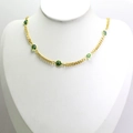 Détail d'un collier doré avec perles d'œil maléfique vert sur un mannequin - Vert