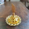 Detail of golden incense burner featuring an intricate hollow base and feather handle - Feather Top