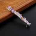 Dettaglio di pietre di cristallo naturali viola e gialle avvolte in filo d'argento su fermaglio - Ametrino con clip d'argento
