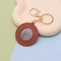 Detail of round heart-shaped brown PU leather keychain with built-in makeup mirror - Round Coffee