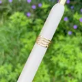 Nahaufnahme eines gestuften, 18 Karat vergoldeten Rings mit wellenförmigem Design - Vierlagiges wellenförmiges Design