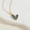Macro shot of heart pendant necklace with colorful shell inlay and gold chain - Colorful