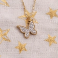 Collier pendentif papillon doré en émail blanc et zircons sur fond de tissu beige - Chaîne Lèvres / Or Émail Zircone Papillon