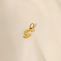 Macro shot of minimalist gold G letter pendant with smooth polished metal finish - Letter-G