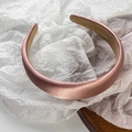 Detailed view of champagne pink satin padded headband with premium silk texture and wide brim - Pink