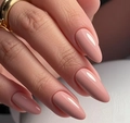 Gros plan d'ongles amandes rose nude brillants avec une bague minimaliste dorée - Rose Mauve Nude (AW299)