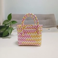 Detail of pink and yellow woven gift basket with dual handles in a cozy home setting - Mini Yellow and Pink Contrast