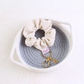 Detalle de coletero de terciopelo beige con colgante de hoja dorada y llavero de metal - Blanco