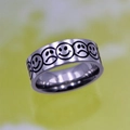 Macro detail of silver titanium steel ring with engraved smile and cry emoji patterns - Mixed Emotions Ring