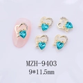 Dettaglio macro del ciondolo per unghie a cuore con scritta Love e strass verde - Stile Zircone Blu Pavone con Base Oro(9403)