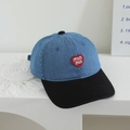 Dettaglio del ricamo a cuore rosso e della scritta min min su cappellino in denim bicolore - 52cm (2-5 Anni) / Blu e Nero