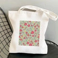 Weiße Segeltuchtasche mit rosa Kosmos-Blumendruck auf einem minimalistischen schwarzen Stuhl - Rechteckiges Rosa Blumenmuster
