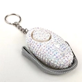 Macro shot of personal safety alarm keychain with sparkling iridescent rhinestones - White