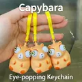 Three-piece set of squeezing capybara keychains with popping eye feature and yellow strap - Popping Eye Keychain Style