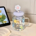 Purple floral glass mug with silicone lid and matching flower straw on a desk - Blue