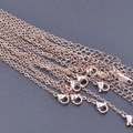 Close-up of rose gold stainless steel cross chains with lobster clasps for jewelry DIY - 1.5mm / Rose Gold