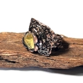 Détail d'une bague artisanale en bronze avec pierre brute jaune sur fond de bois - Citrine