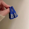 Detailed shot of double-layered blue cat eye earrings with golden metal letter B accent - 52# Silver Needle - Blue Textured Letter B Earrings