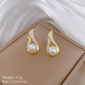 Détails macro de boucles d'oreilles dorées avec perles blanches et diamants sur écrin - Boucles d'Oreilles Clous (B530)