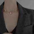 Collar de doble capa dorado con perlas barrocas en modelo con traje gris oscuro - Dorado