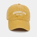 Gros plan de la broderie Brooklyn blanche sur la casquette en coton jaune délavé - Jaune