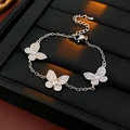 Detailed shot of silver butterfly bracelet with three rhinestone pendants on black tray - Butterfly Bracelet (HB3159) / Silver