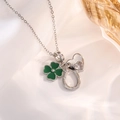 Macro detail of silver necklace with green clover, zircon heart, and horseshoe charms - Silver Heart Clover Style