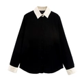 Détail du sweat en velours noir avec col blanc contrasté et poignets boutonnés - Hauts
