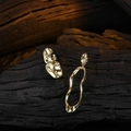 Pendientes asimétricos dorados estilo lava con textura de metal fluido sobre madera - Cobre / Dorado