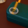 Detalle de anillo de resina gris con colgante de cruz plateada y textura translúcida - Transparente Plata