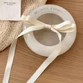 Eleganter cremefarbener Satin-Haarclip mit langen Bändern im französischen Vintage-Stil - Gebrochenes Weiß