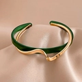 Gold plated titanium bangle featuring wavy emerald resin inlay on silk background - Gold with Green Wave Style