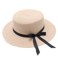 Gros plan d'un chapeau de paille beige à sommet plat avec ruban en gros-grain noir - Rose Clair