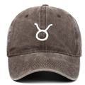 Close-up of Taurus zodiac embroidery and washed cotton fabric on brown baseball cap - Coffee