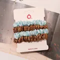 Set of four satin scrunchies in light blue and bronze on white cardstock - Sky Blue and Gold